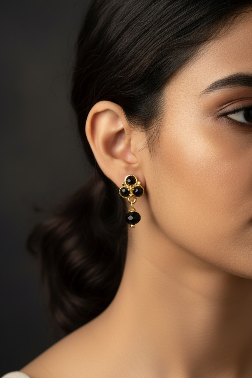 Indian woman wearing small gold black onyx trefoil cross cluster drop earrings